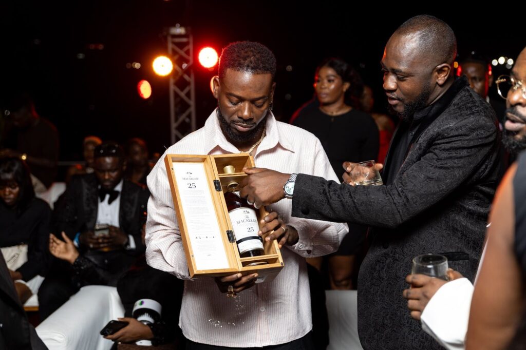 Adekunle Gold and Hammed Adebiyi, Senior Brand Manager for West and Central Africa, Edrington, with The Macallan 25 Years Old Sherry Oak.