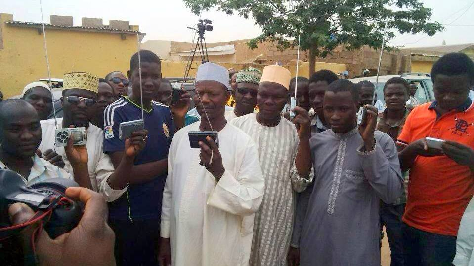 A community gathers to listen to radio programming